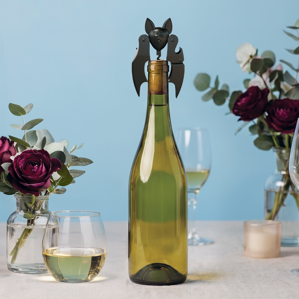 Vleermuiskurkentrekker naast een geopende fles witte wijn
