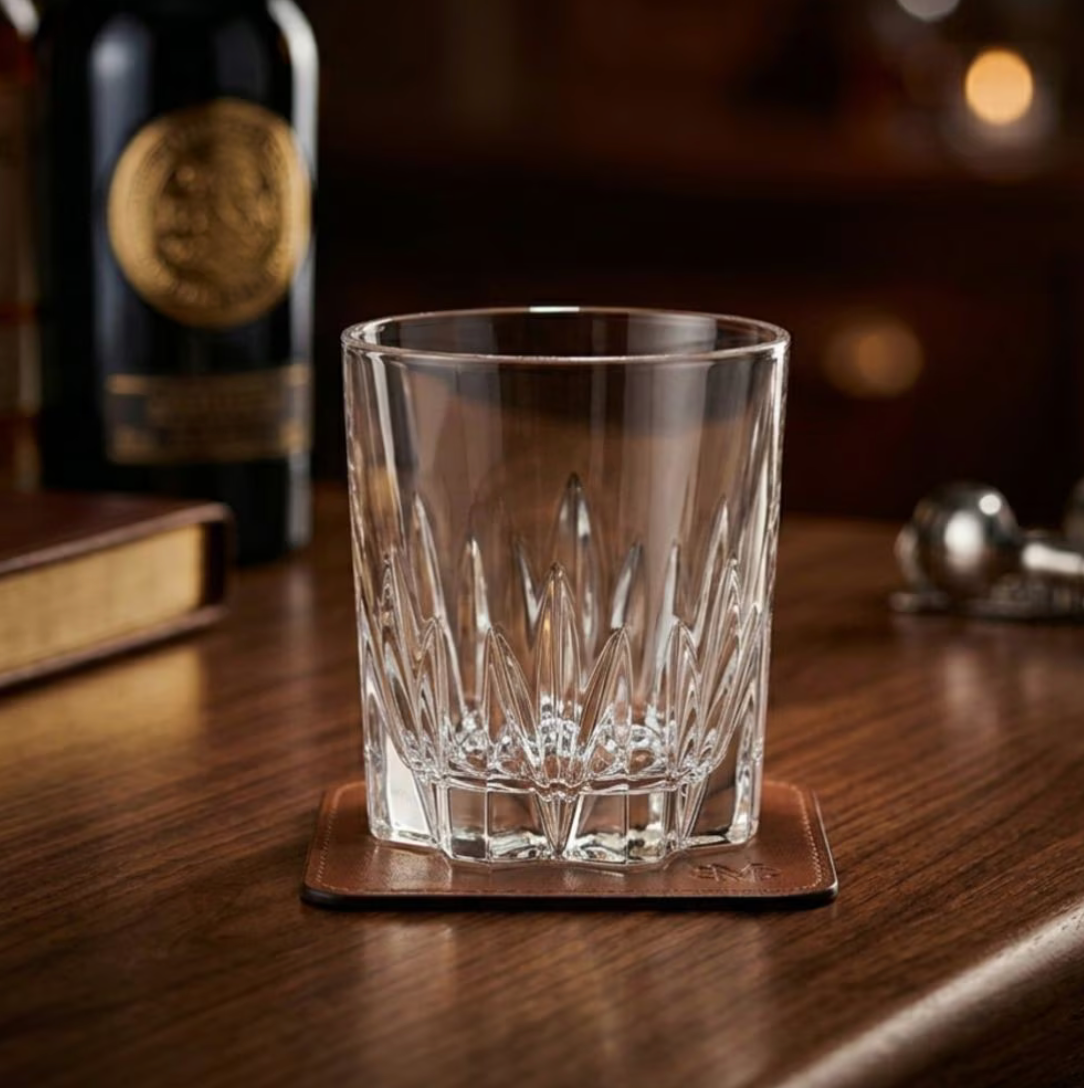Een Gala-tumbler op een houten bar naast een fles whisky