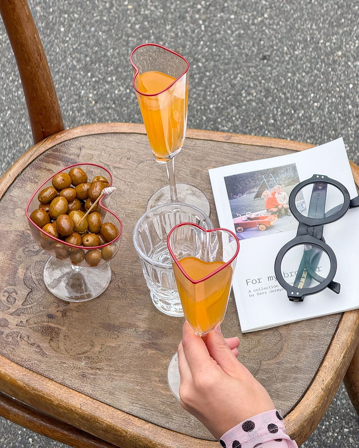 Twee hartvormige champagneglazen met rode rand op een feestelijk gedekte tafel