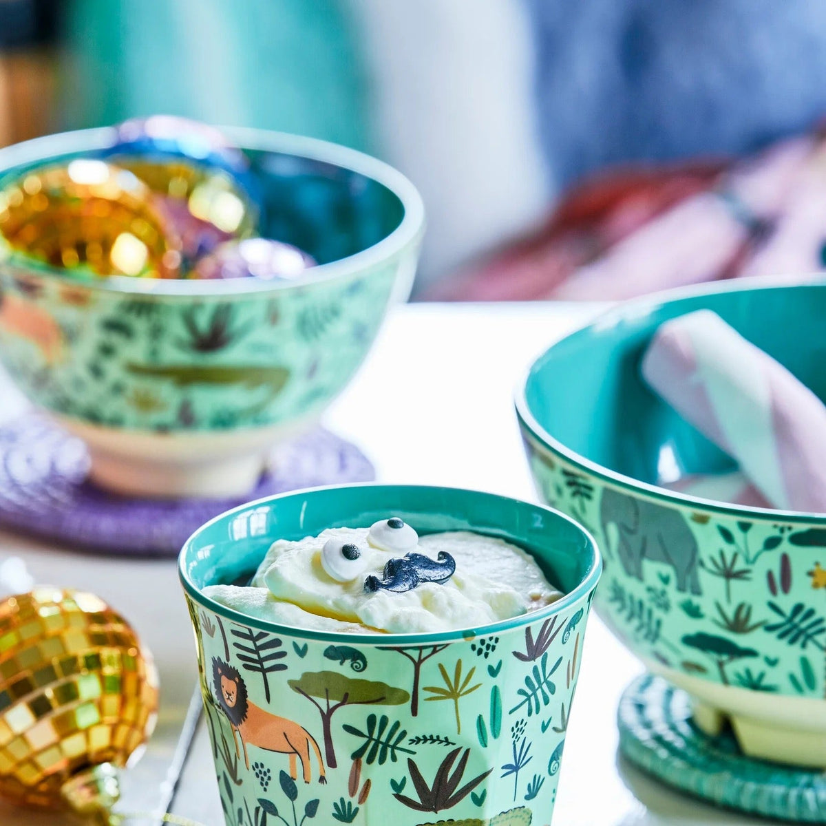 Groene kinderkom met jungleprint naast grotere kommen met dezelfde print op tafel