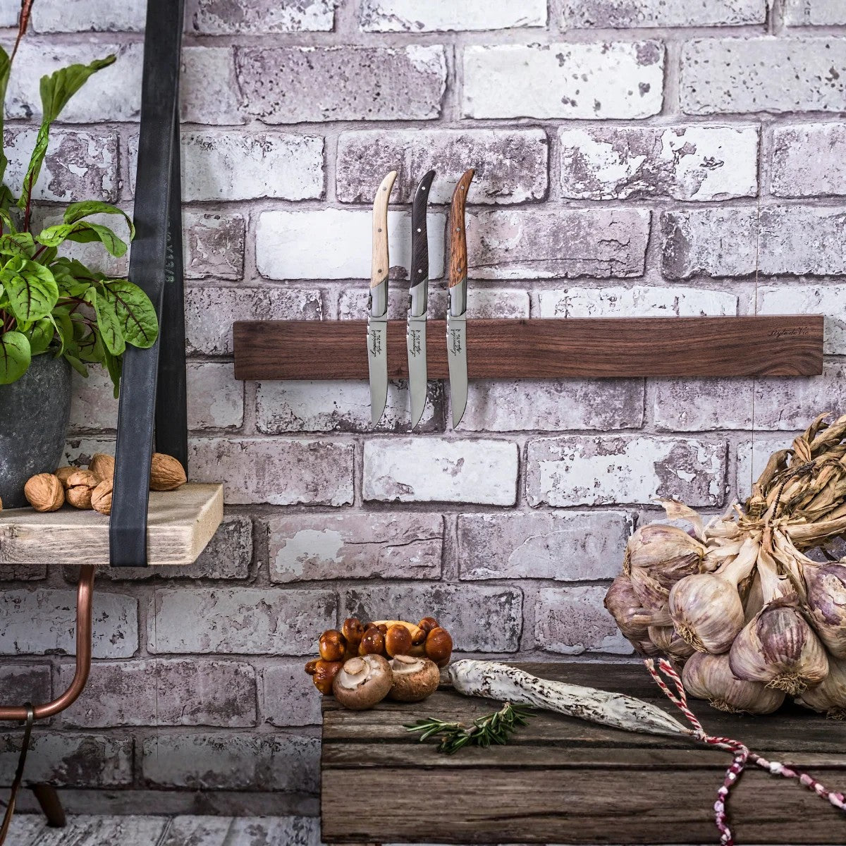 Het messenrek aan een bakstenen muur met drie messen