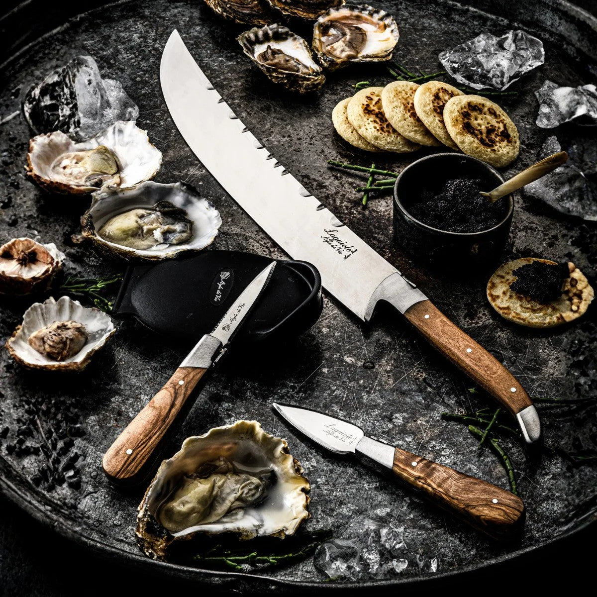 De champagnesabel bij oesters, ijs en blinis op een donkere ondergrond