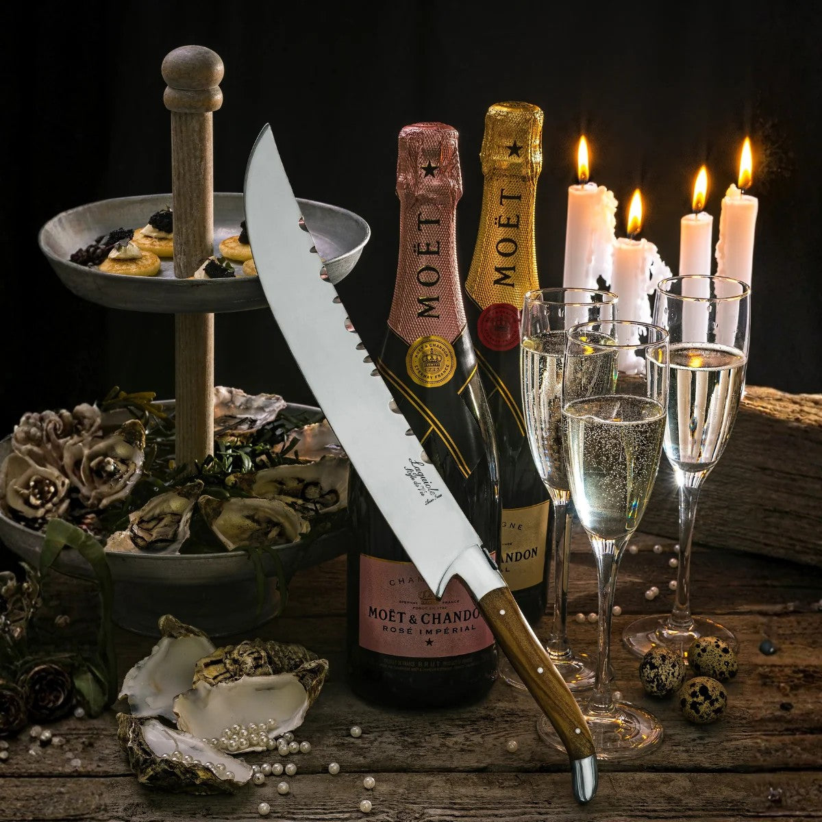 De sabel naast flessen champagne, glazen en brandende kaarsen
