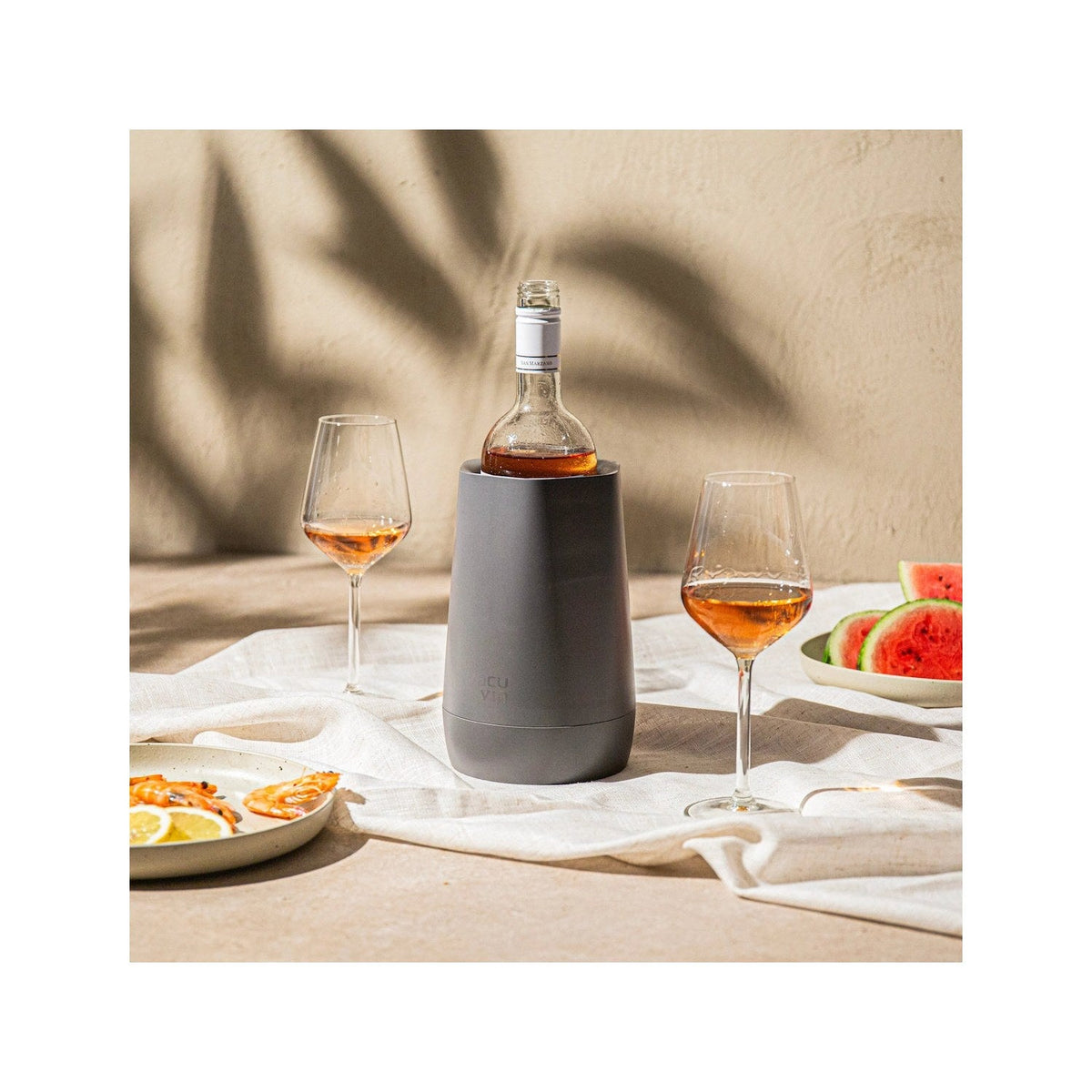 De donkergrijze Hexo wijnkoeler met fles witte wijn op een gedekte tafel