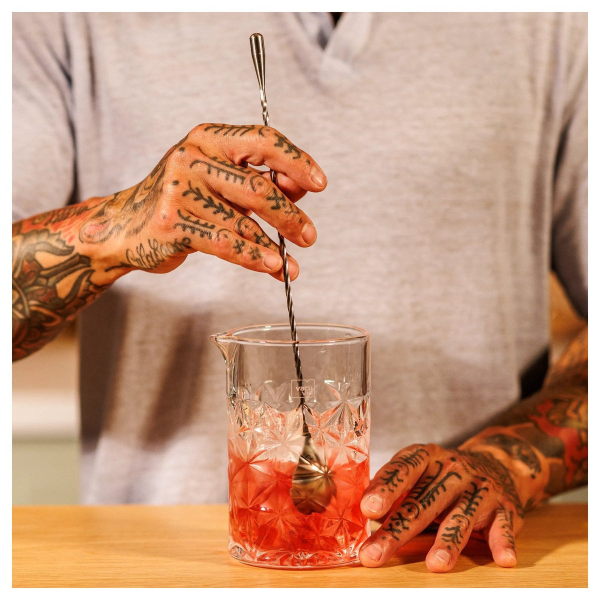 Een bartender gebruikt de barlepel bij het maken van een cocktail