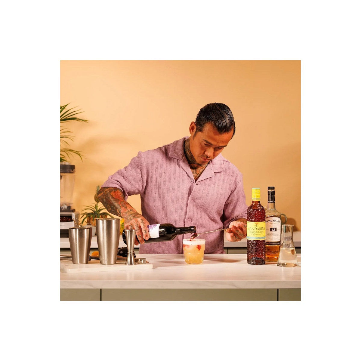De barlepel roert in een glas met rode cocktail