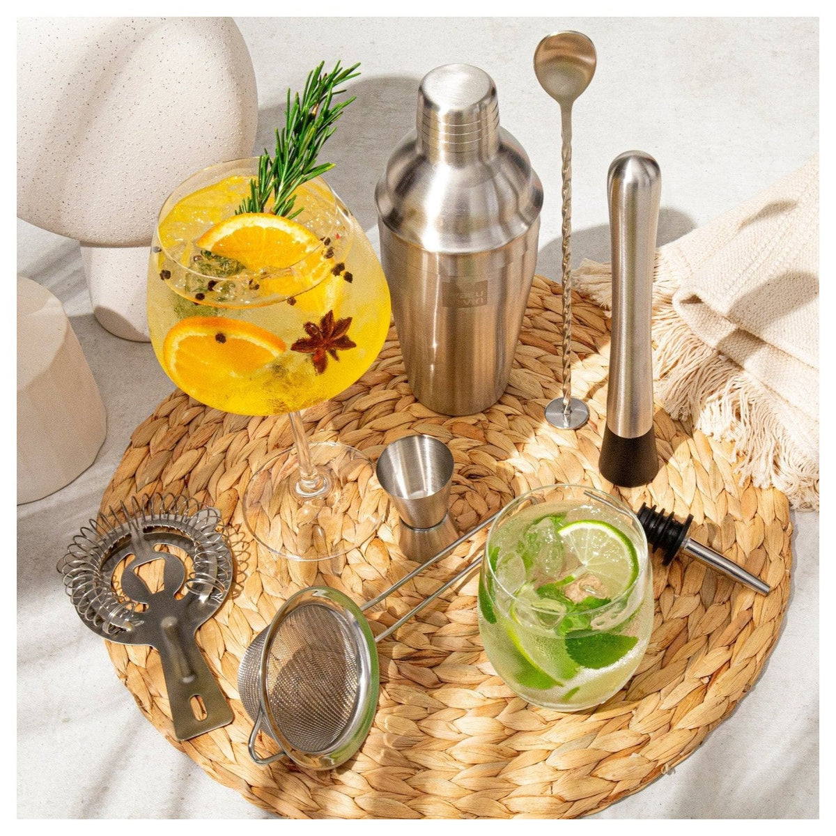 De zeven onderdelen van de cocktailset van bovenaf op een houten tafel