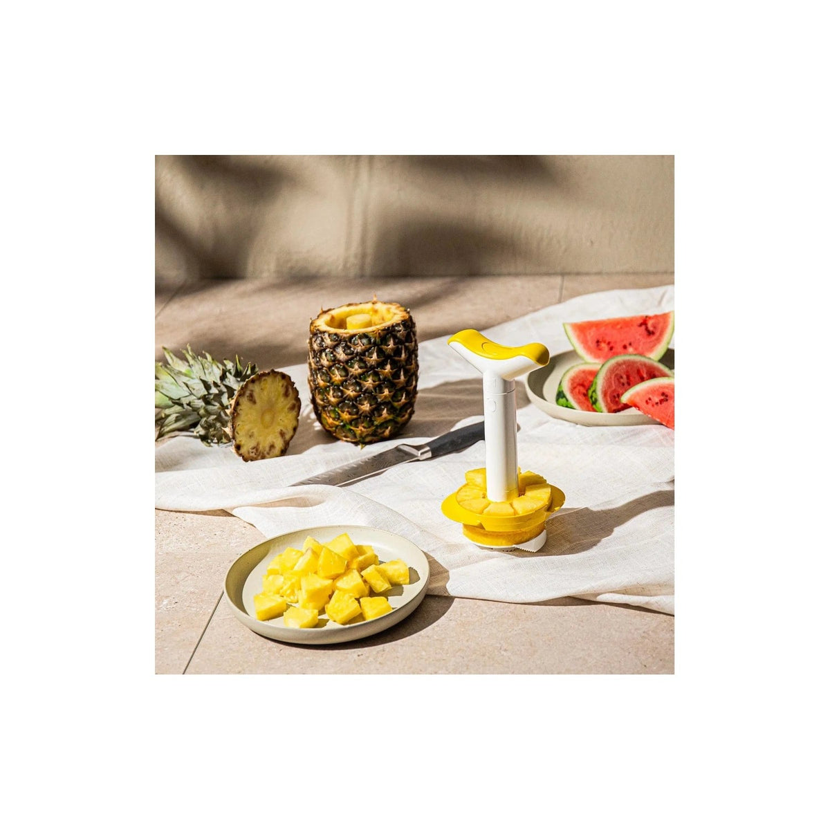 De ananassnijder met partjesmaker halverwege een ananas gedraaid
