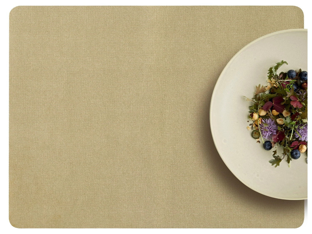 Shoku placemat Soft Beige van bovenaf met een crèmekleurig bord met salade en eetbare bloemen