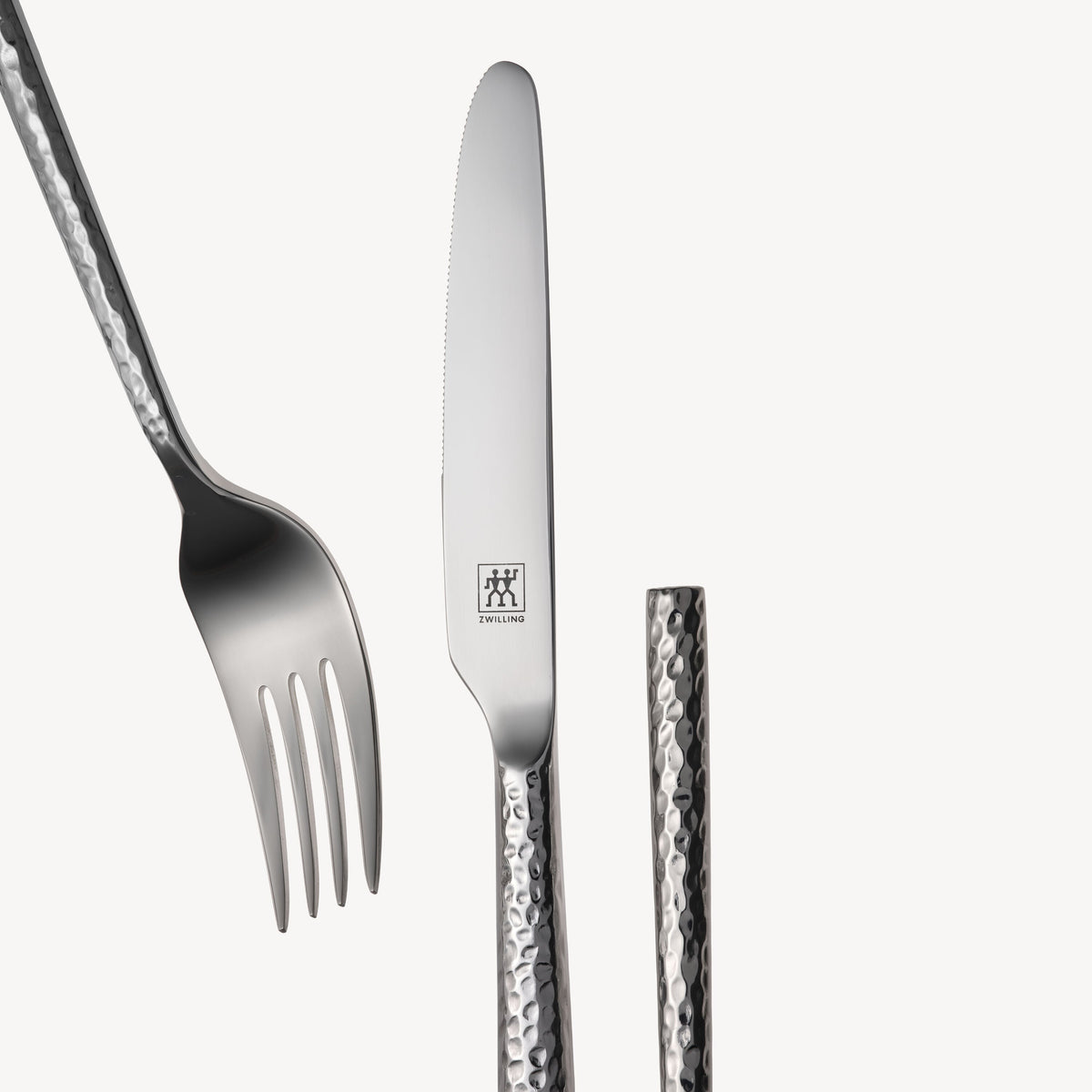 Close-up van het gekartelde dinermes en de gehamerde steel